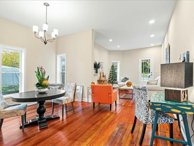 dining area with hardwood / wood-style flooring and a notable chandelier