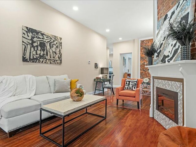 living room with wood-type flooring and a large fireplace