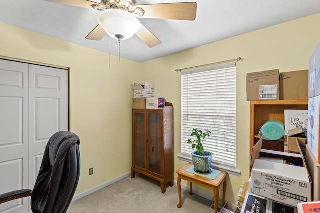 carpeted office space featuring ceiling fan