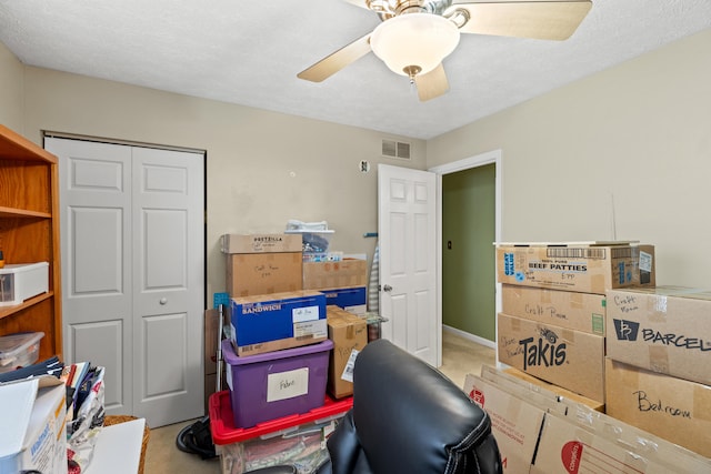 carpeted office space with ceiling fan and a textured ceiling