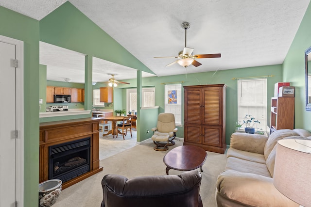 carpeted living room with ceiling fan, lofted ceiling, and a textured ceiling