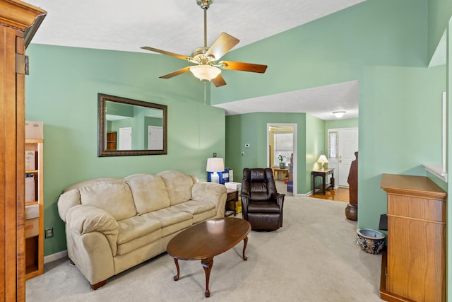 living room with a textured ceiling, ceiling fan, light colored carpet, and vaulted ceiling