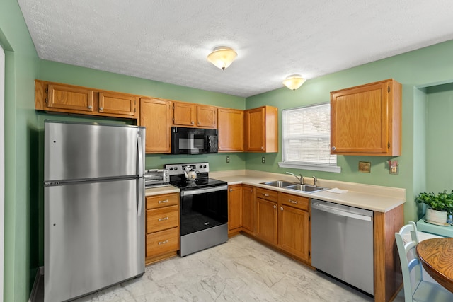 kitchen featuring a textured ceiling, sink, and appliances with stainless steel finishes