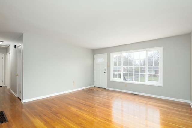 unfurnished room with visible vents, baseboards, and wood finished floors