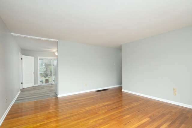 spare room with baseboards, visible vents, and light wood-style floors