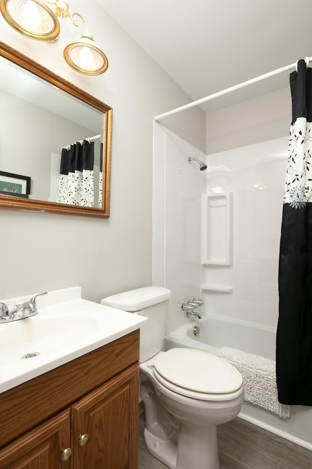 bathroom featuring shower / bathtub combination with curtain, vanity, toilet, and wood finished floors