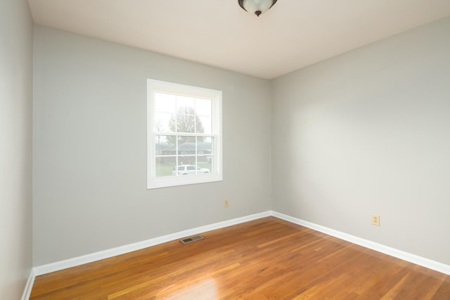 spare room with baseboards, visible vents, and light wood-style floors