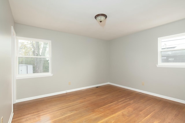 unfurnished room with light wood finished floors and baseboards