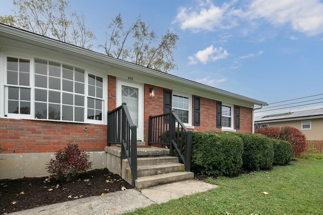 ranch-style house with brick siding and a front lawn