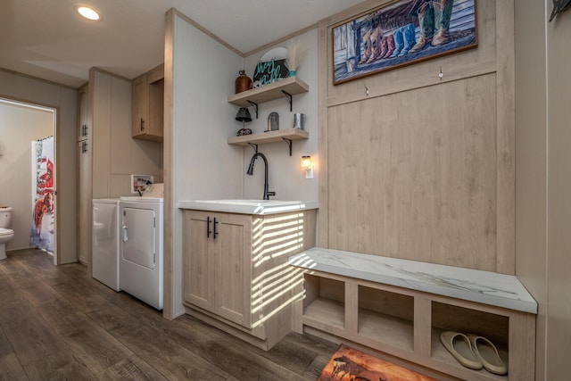 laundry room featuring wood walls, washer and dryer, dark wood-type flooring, cabinets, and crown molding