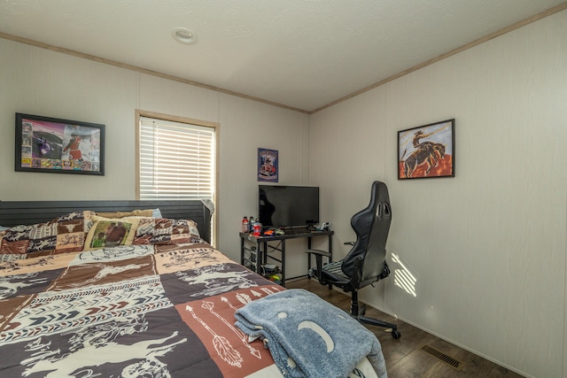 bedroom with ornamental molding and dark hardwood / wood-style floors