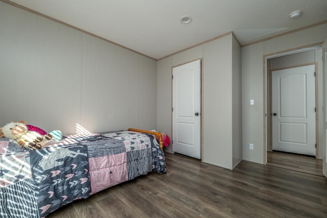 bedroom with ornamental molding and dark hardwood / wood-style flooring