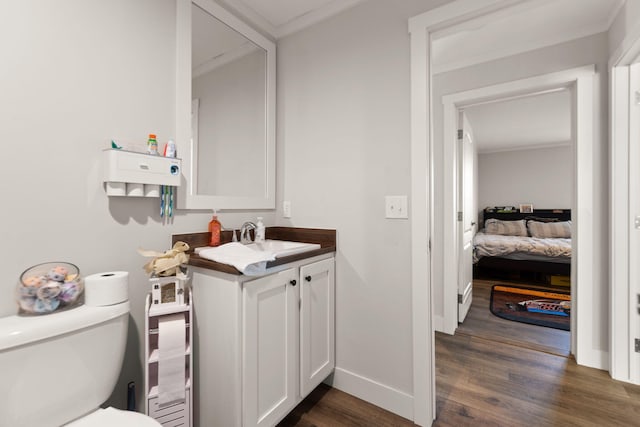 bathroom with vanity, hardwood / wood-style flooring, toilet, and crown molding