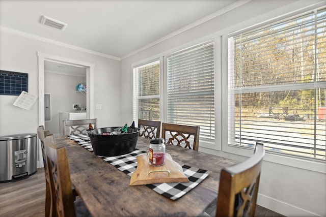 dining area featuring electric panel, hardwood / wood-style floors, ornamental molding, and washer / dryer