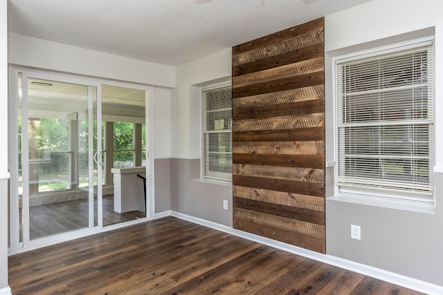 empty room featuring dark hardwood / wood-style flooring and a textured ceiling