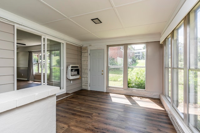 unfurnished sunroom featuring heating unit and a wealth of natural light