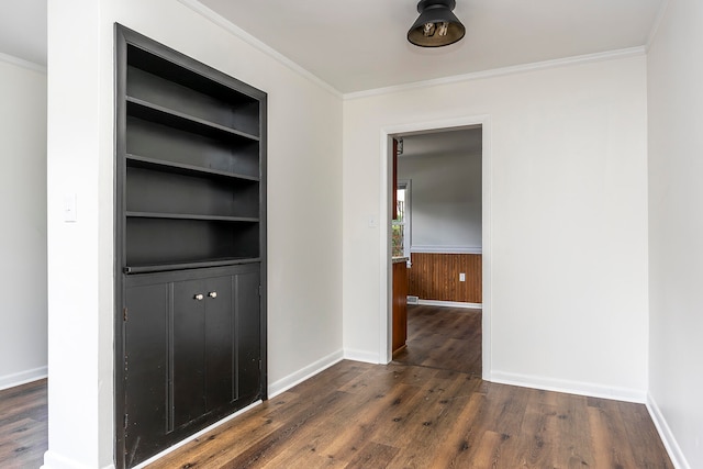 hallway featuring built in shelves, dark hardwood / wood-style flooring, and ornamental molding