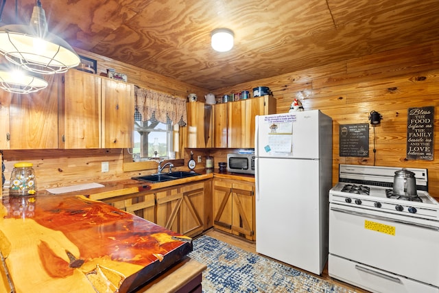 kitchen featuring white appliances, wooden ceiling, wooden walls, and sink