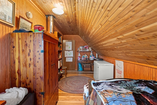 bedroom featuring wood ceiling, wooden walls, white fridge, light hardwood / wood-style floors, and lofted ceiling