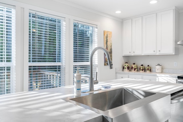 kitchen with white cabinets, stainless steel dishwasher, and sink