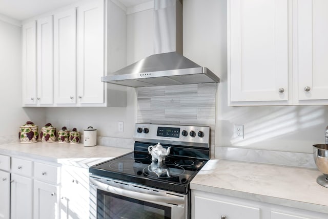 kitchen with white cabinetry, stainless steel electric range oven, and wall chimney range hood