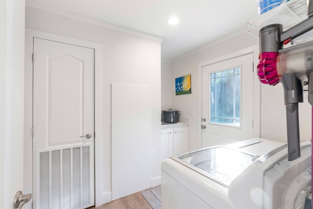 laundry room with light wood-type flooring, crown molding, and washing machine and clothes dryer