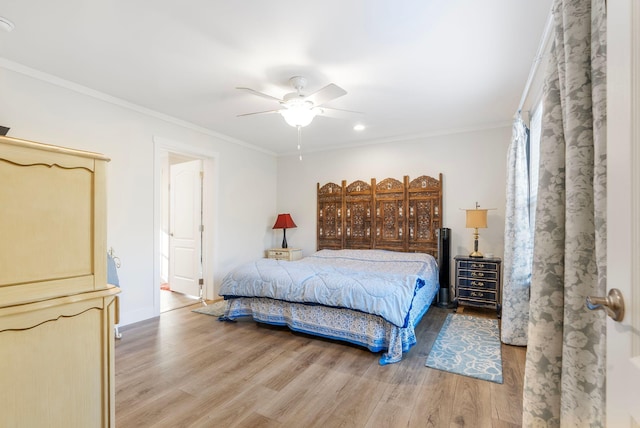 bedroom featuring hardwood / wood-style flooring, ceiling fan, and crown molding