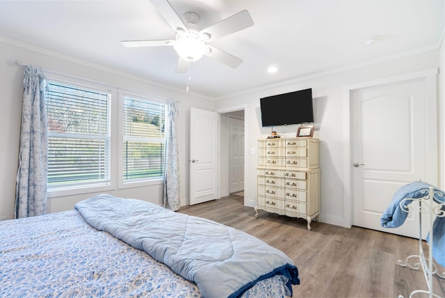 bedroom featuring ceiling fan, crown molding, and hardwood / wood-style flooring