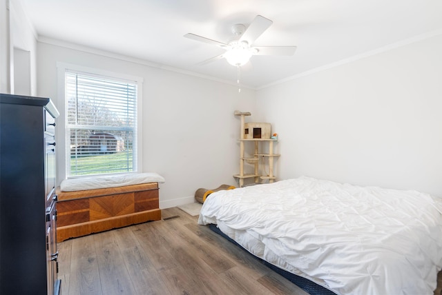 bedroom featuring hardwood / wood-style flooring, ceiling fan, and crown molding