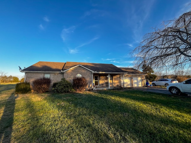 ranch-style home featuring a garage and a front lawn