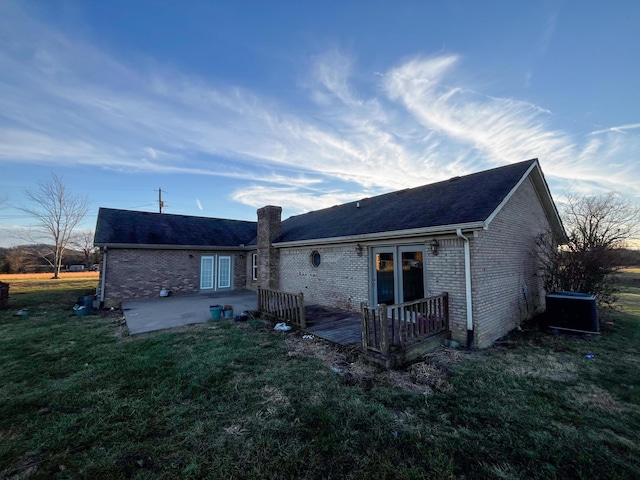 back of house with a yard, a patio area, and central air condition unit