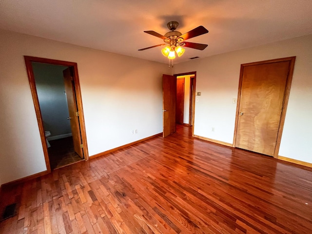 unfurnished bedroom featuring connected bathroom, ceiling fan, and wood-type flooring