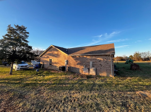 view of home's exterior featuring central AC and a yard