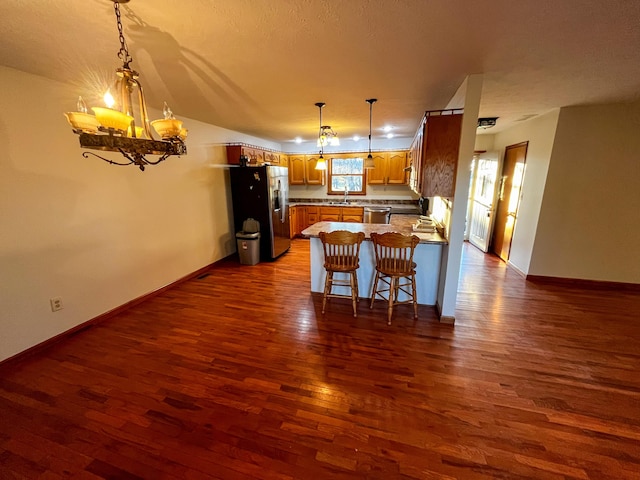 kitchen featuring sink, an inviting chandelier, kitchen peninsula, a breakfast bar area, and appliances with stainless steel finishes