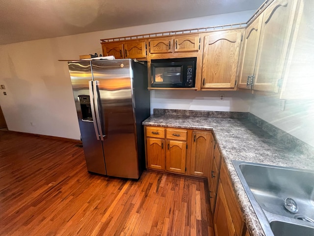 kitchen featuring stainless steel fridge, hardwood / wood-style flooring, and sink