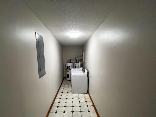 laundry area featuring a textured ceiling, electric water heater, washer and clothes dryer, and electric panel