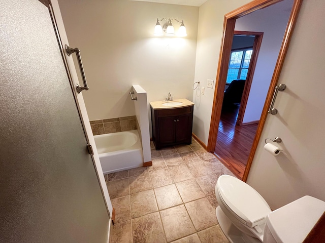 bathroom with tile patterned floors, a tub, vanity, and toilet