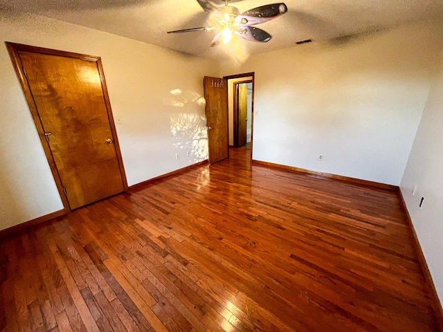 unfurnished bedroom with hardwood / wood-style floors, a textured ceiling, a closet, and ceiling fan