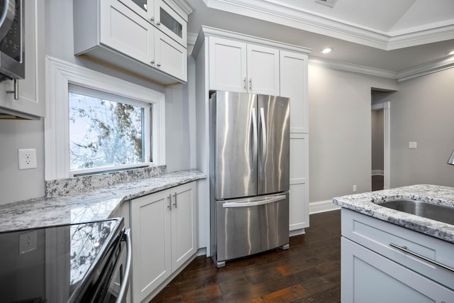 kitchen with ornamental molding, a sink, dark wood-style floors, white cabinetry, and stainless steel appliances