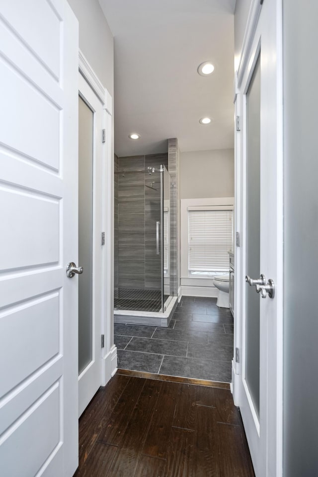 full bathroom featuring recessed lighting, a shower stall, toilet, and wood tiled floor