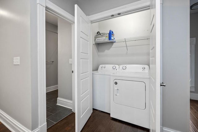 laundry area with laundry area, baseboards, dark wood-type flooring, and washer and clothes dryer