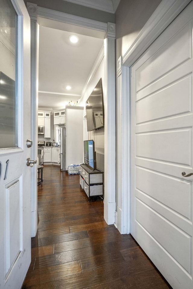 hallway with recessed lighting, crown molding, and dark wood-type flooring