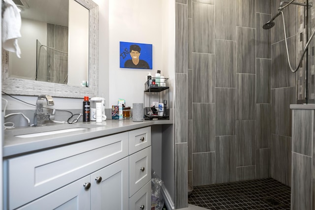 bathroom featuring a tile shower and vanity