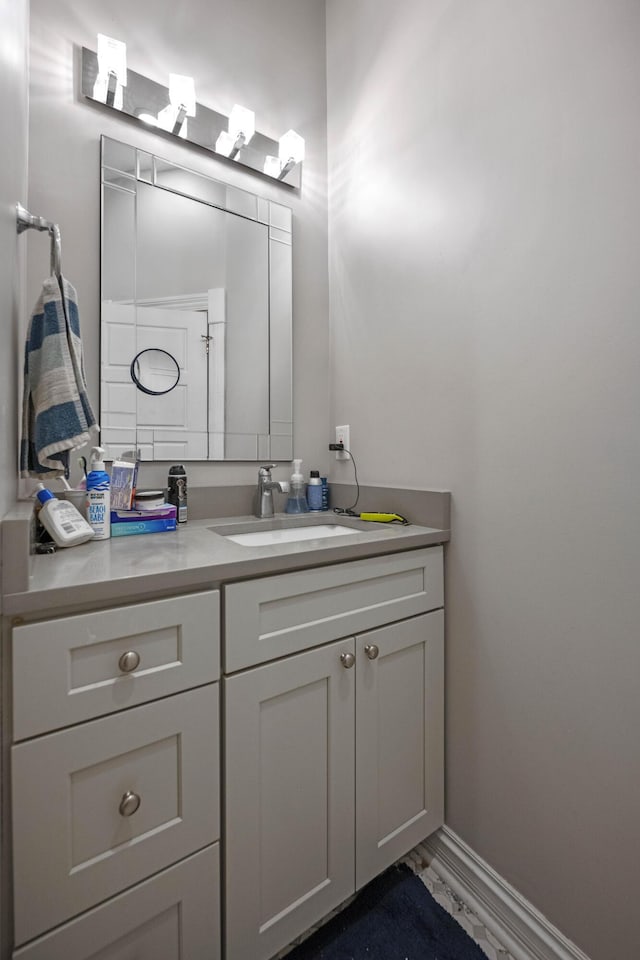 bathroom with vanity, baseboards, and marble finish floor