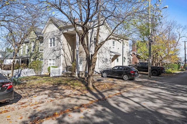 view of home's exterior featuring fence and a chimney