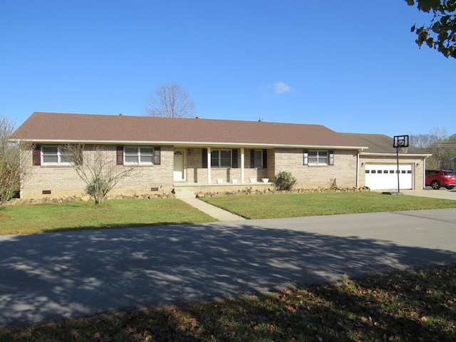 ranch-style home with covered porch, a garage, and a front yard