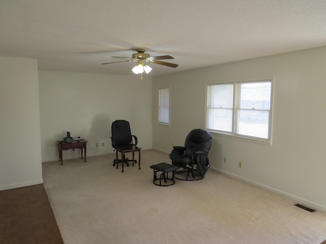 dining area with ceiling fan, light colored carpet, and a textured ceiling