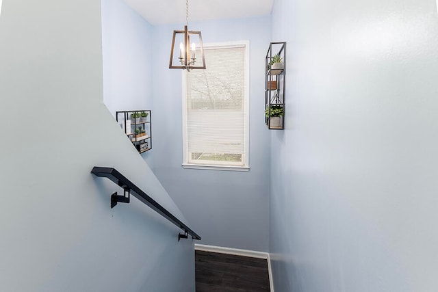 stairs featuring hardwood / wood-style floors and an inviting chandelier