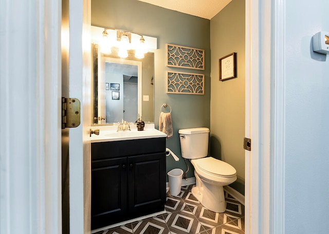 bathroom featuring tile patterned flooring, vanity, and toilet