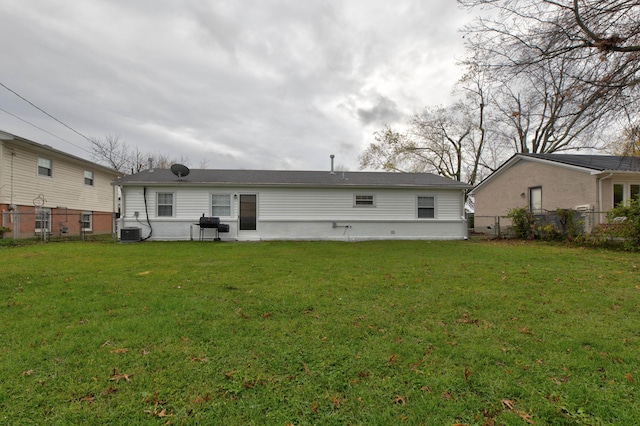 back of house with a yard and central air condition unit